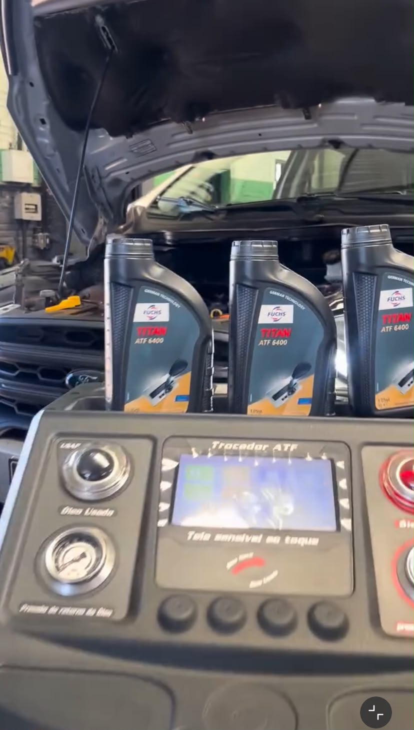 Equipamento de troca de óleo de câmbio e frascos de fluido junto ao veículo na Pit Stop